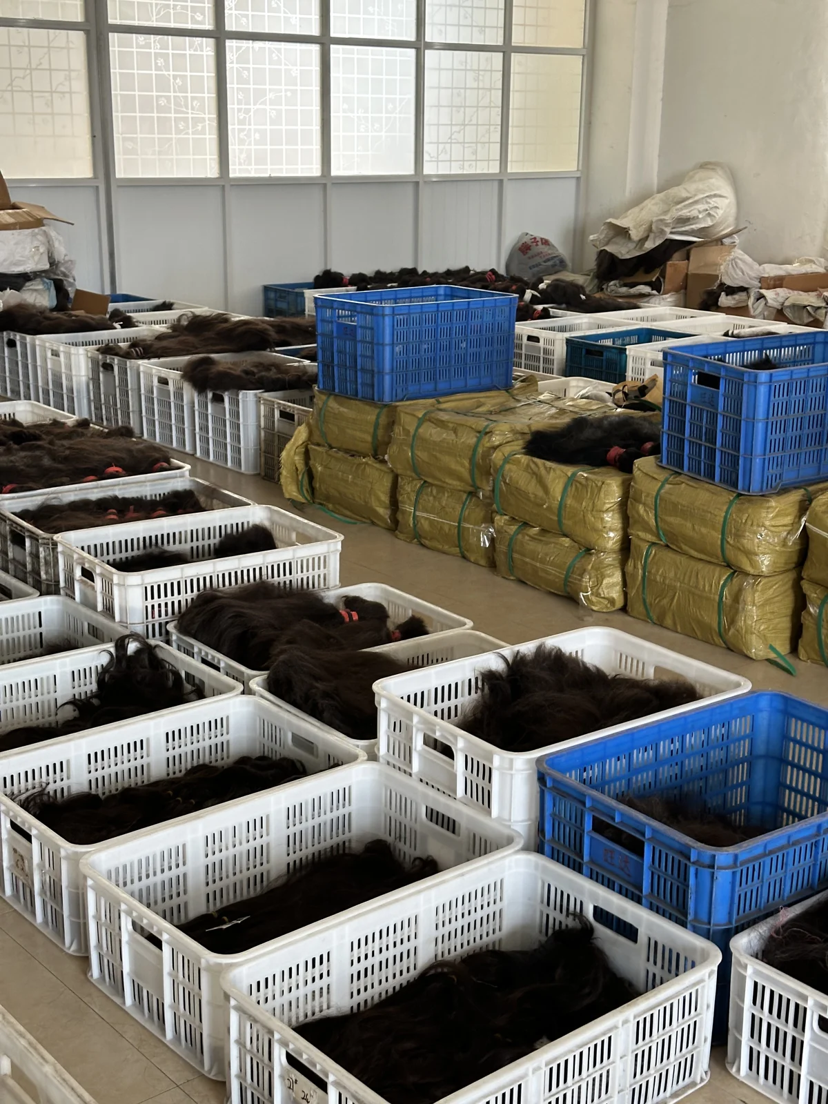 Raw hair bundles stored in separate baskets in the material storage area