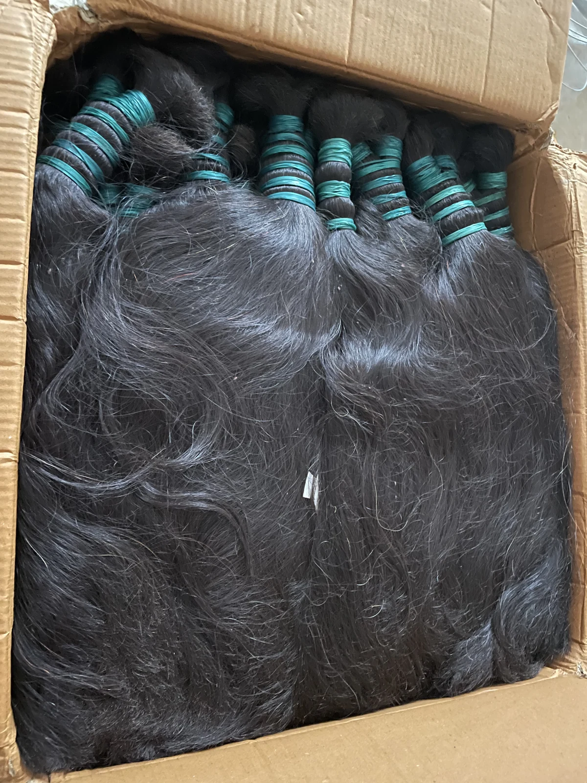 Black raw hair bundles tied together before selection and production