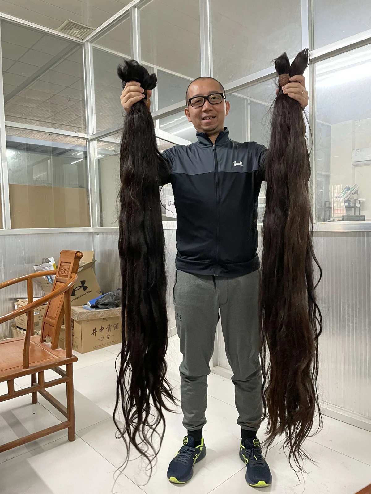 Long black hair bundles held up during our raw hair selection process