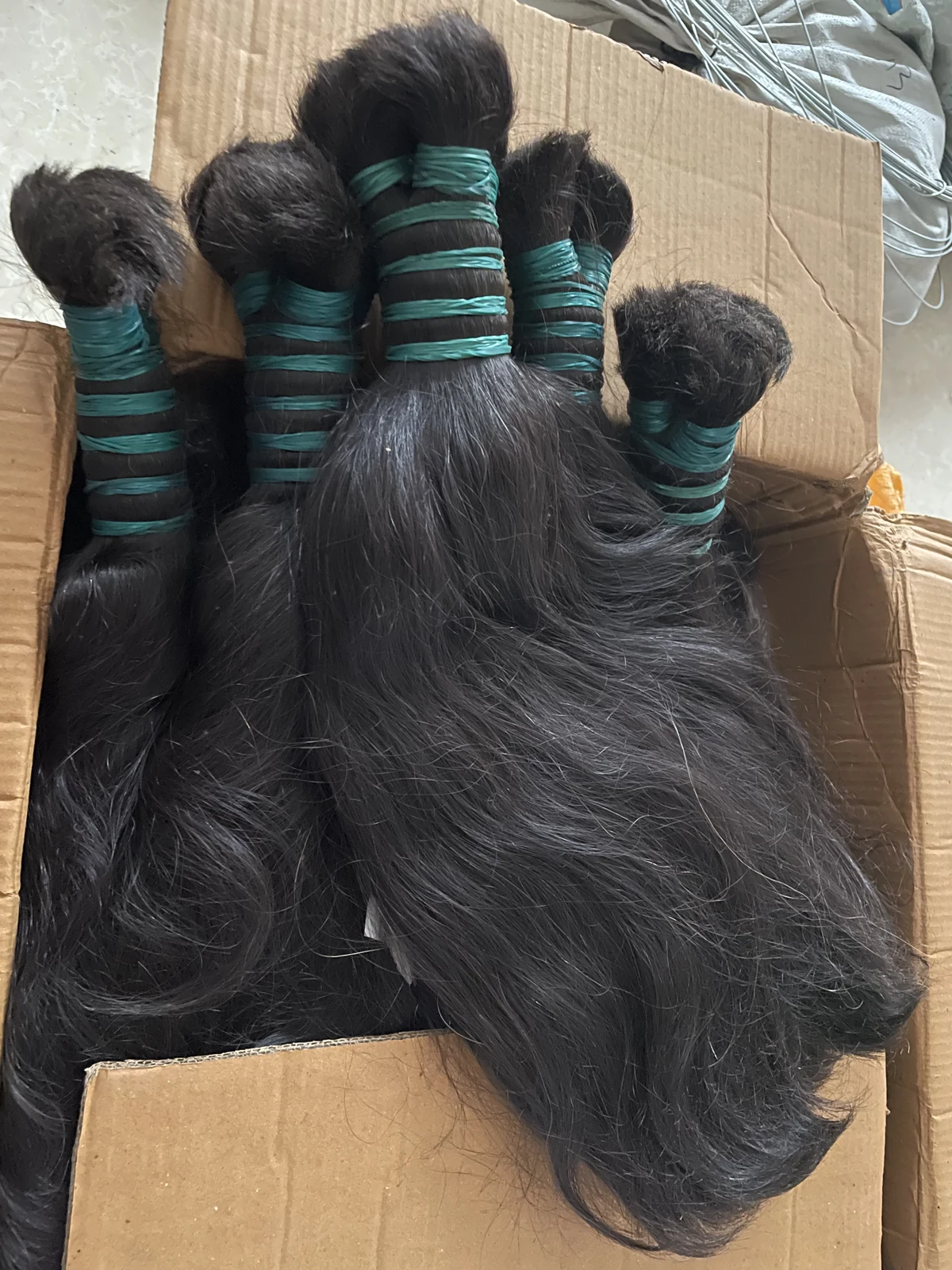 Black raw hair bundles tied together before selection and production